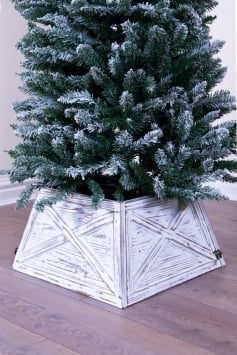 Slim Christmas tree with wooden tree skirt