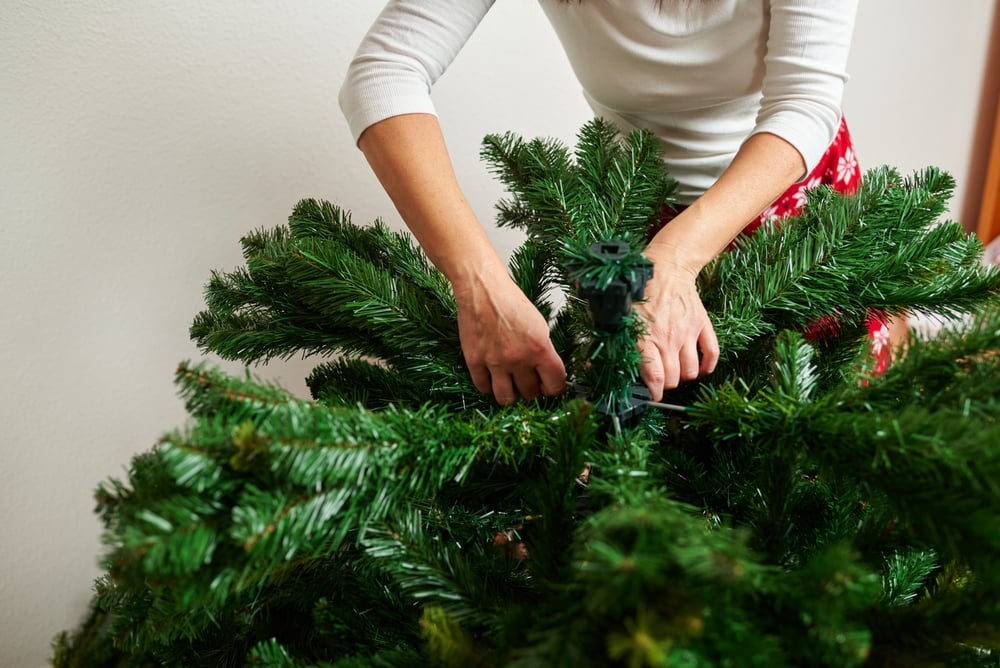 Person assembling an artificial christmas tree