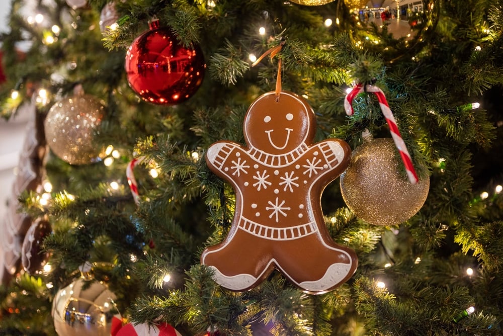 Gingerbread man ornament, candy canes and baubles on a Christmas tree