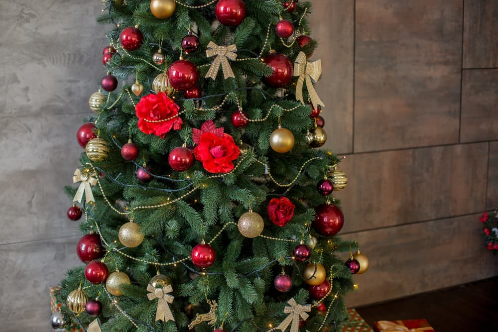 Room with chair, fireplace and slim Christmas tree with decorations