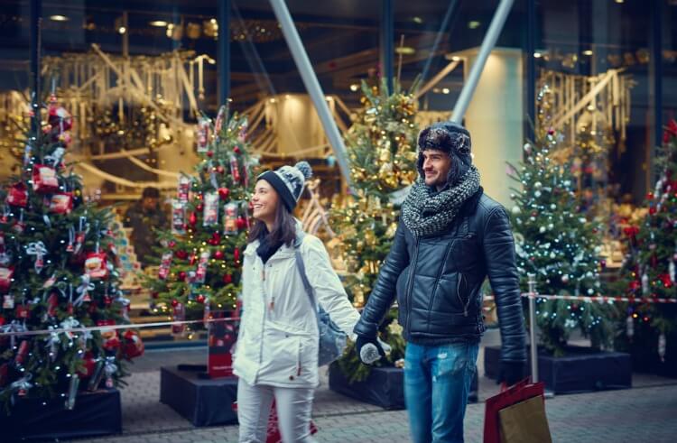 Sshoppers walking past a Christmas themed window display