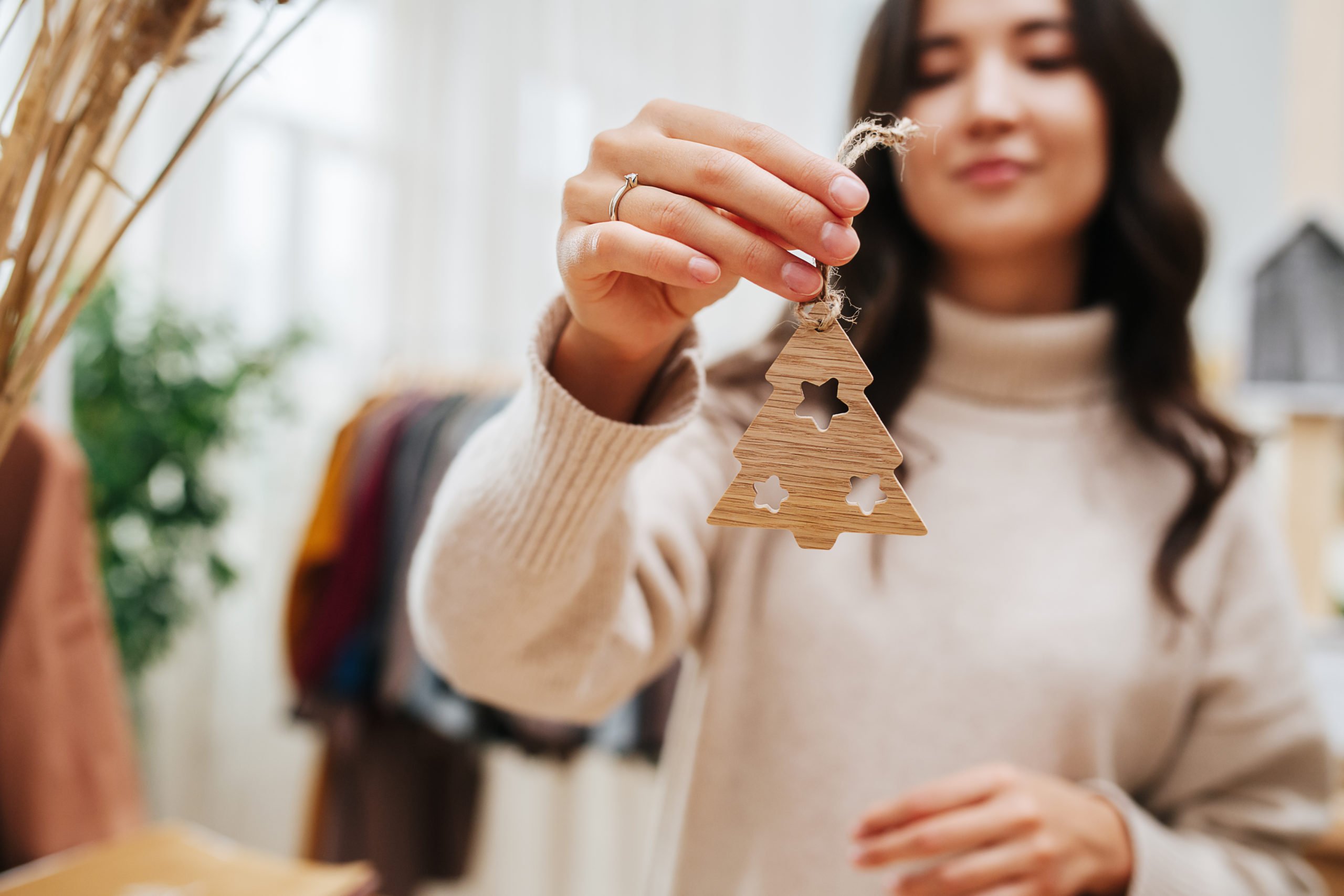 a woman holding a christmas tree ornament