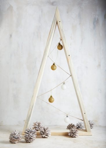 a minimalist christmas tree made from two pieces of wood in a triangle